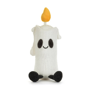 Front view of a white corduroy candle plush toy with a yellow-orange flame on top. It has a black mouth and eyes, black sparkly patches around it's eyes and black sparkly feet. It is shown on a white background. 