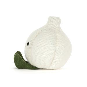 Side View of a knitted white-coloured garlic plush toy with olive green feet and an embroidered smiley face, shown on a white background.