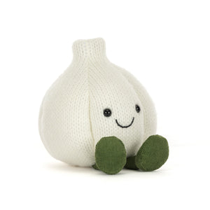 A knitted white-coloured garlic plush toy with olive green feet and an embroidered smiley face, shown on a white background.