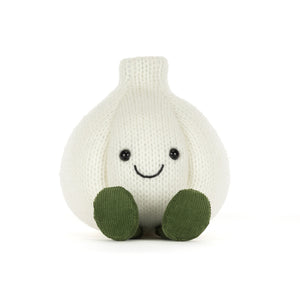 Front view of a knitted white-coloured garlic plush toy with olive green feet and an embroidered smiley face, shown on a white background.