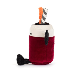 Side view of a plush toy shaped like a can of pop dressed like a vampire with fangs. The plush features a deep red velvet body, a white top, black bat wings, a black-and-white striped straw, and a decorative orange slice garnish. The plush is shown on a white background.