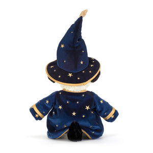 Back view of a plush black and white dog toy dressed as a wizard, featuring a navy blue velvet robe and pointed hat with gold star patterns and trim, set against a plain white background.