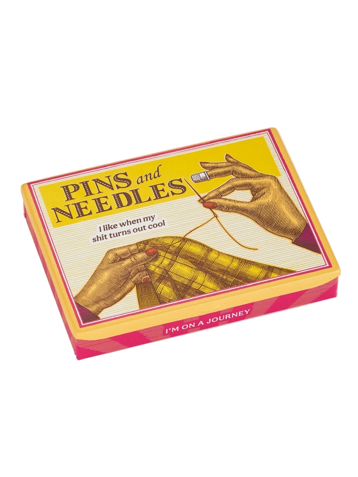 Image of a pocket storage tin featuring a vintage style illustration of someone holding a needle and sewing an item. The text 'Pins and Needles' and 'I like when my shit turns out cool' is printed on the top.