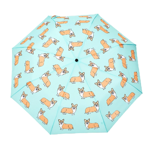 Opened blue umbrella with a corgi print and a wooden duck head shaped handle on a white background.