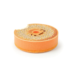 Image of a kitchen sponge in the style of asmiling bagel-shaped donut with a bite chunk taken from it. The sponge sits on a white background. 