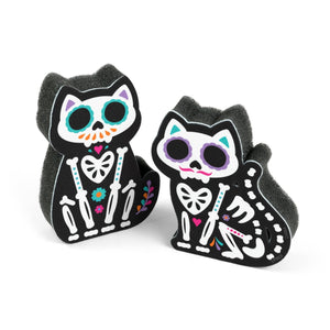 Image of two sugar skull cat-themed kitchen sponges on a white background.