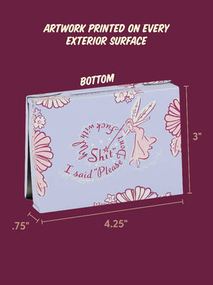 A product dimension diagram showing the back view of a pocket-sized storage tin with an illustration of a pink fairy holding a wand over the text 'I said please don't fuck with my shit'. Floral designs are shown around the edges of the tin. 