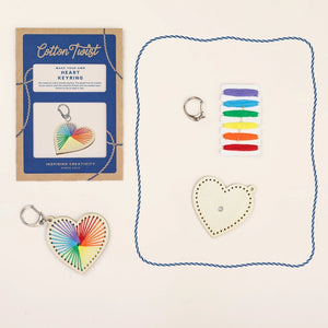 Cotton Twist keyring-making kit with colorful keychain, wooden heart and threads on a white background.