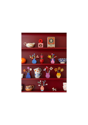 Red bookshelf with various 3D pop-up models and ornaments on a white background.