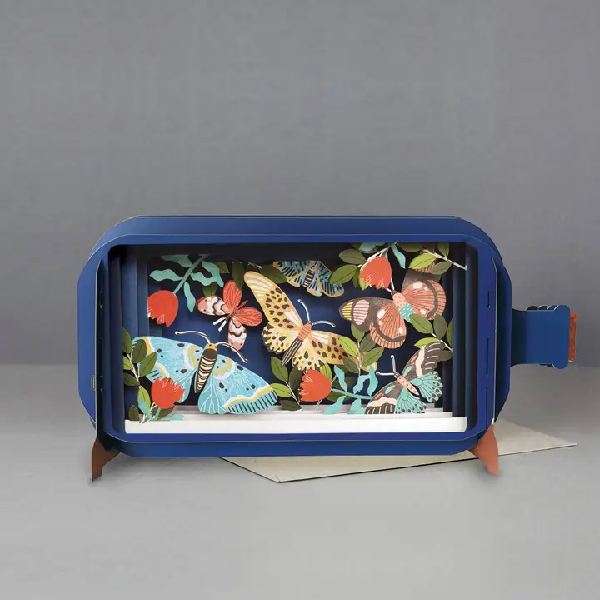 blue bottle pop up card. the intricate paper cuttings depict butterflies, red tulips, and leaves