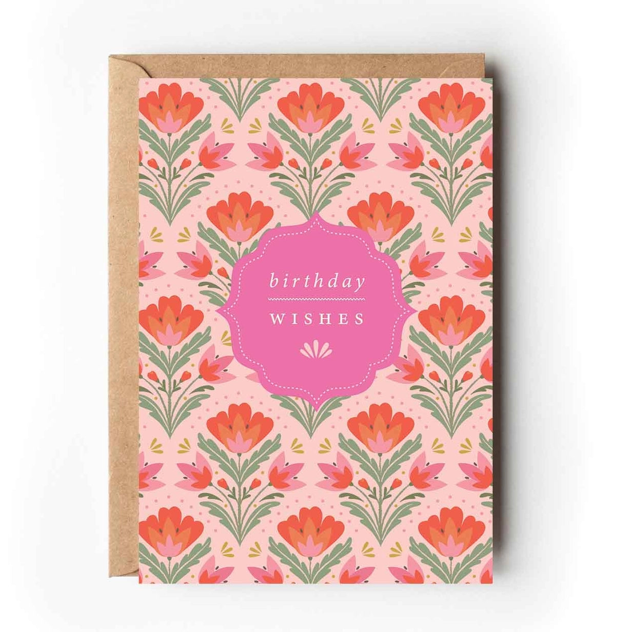 Greeting card with orange, pink and green symmetrical botanical patterns on a light coloured background. The text 'Birthday Wishes' is printed on a pink ornate shape in the centre of the card. 