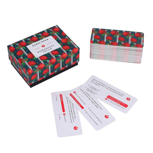 Box with an abstract print featuring roses and swords and the text  'Romantasy Trivia', beside a deck of trivia cards on a white background.