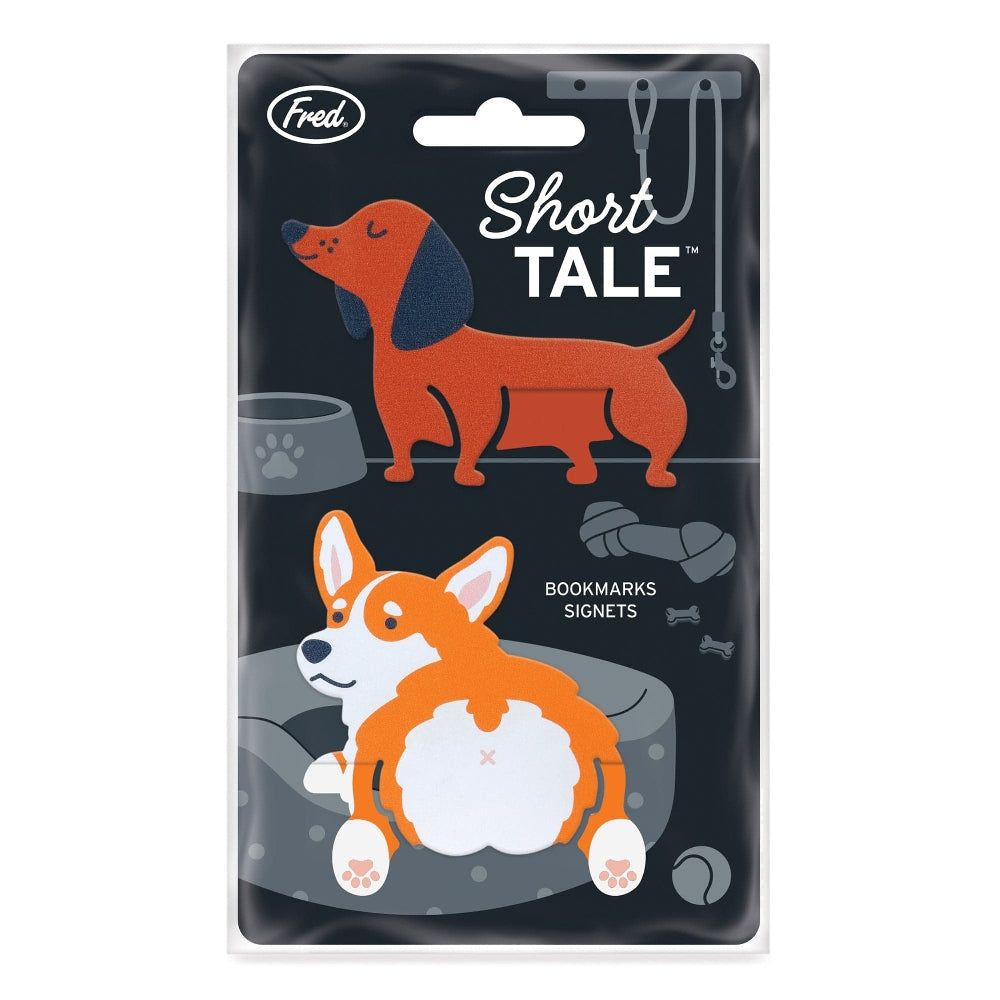 Image of two dog-shaped bookmarks in the shape of an orange and white corgi and a brown and black dachschund. The bookmarks are shown attached to the product packaging, on a white background. The text 'Short Tale' and the company branding are shown at the top of the packaging. 