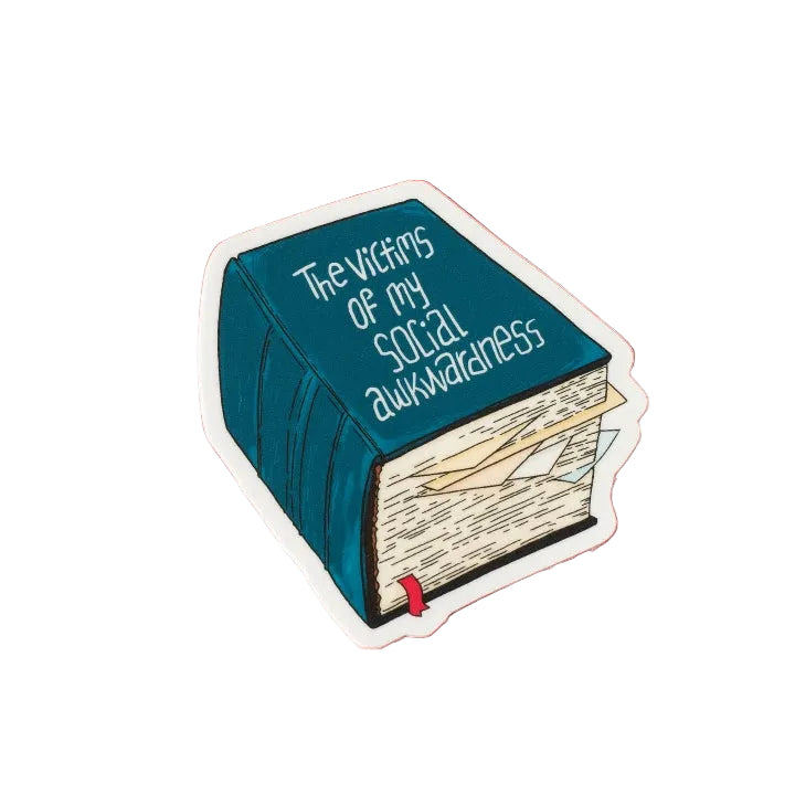 A vinyl sticker featuring an illustration of a thick book with a blue cover. The text 'The victims of my social awkwardness' is printed on the cover. The sticker sits on a white background. 