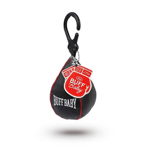 The image shows a black punch bag shaped hanging baby toy attached to a clip. A red tag in the shape of a boxing glove shows the company branding and text 'Buff Baby'. The hanging toy sits on a white background. 