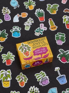 Image showing a packaging box for a 'Downright Joyful Houseplants' themed sticker set. Stickers of colourful colourful potted plants with faces surround the box. The box and stickers sit against a black surface.
