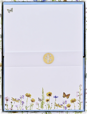 white blank card in a flowery box. the bottom of the card has flowers and butterflies. a single butterfly is at the top left of the card