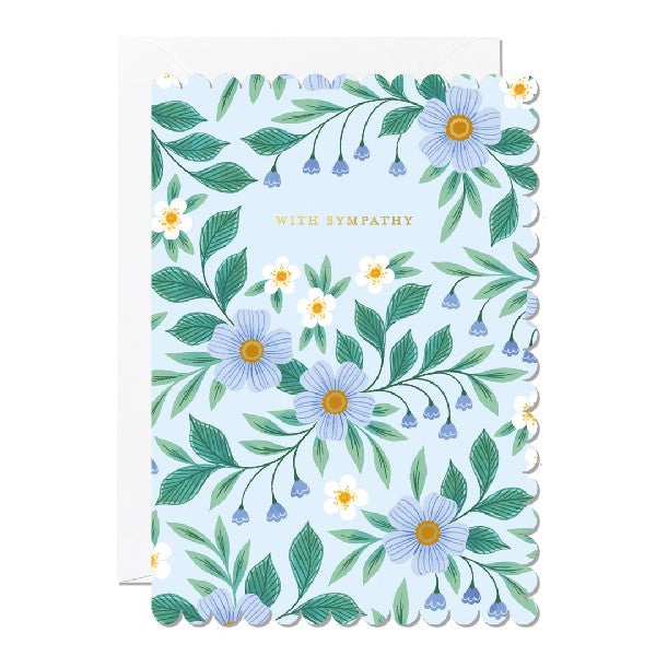 blue sympathy card with rounded, hill-like sides. illustrated blue and white flowers decorate the card with sinuous leaves. between flowers, top text reads "with sympathy" in gold