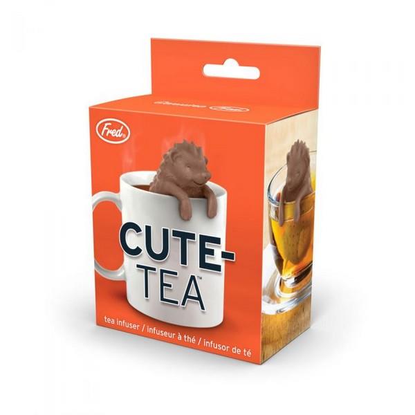 tea infuser in the shape of a brown smiling hedgehog propping its head and paws above a white cup